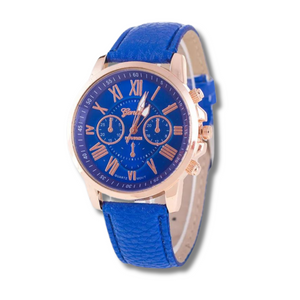 dark blue faced watch with roman numeral numbers which are gold with a gold trim and a blue strap on a white background