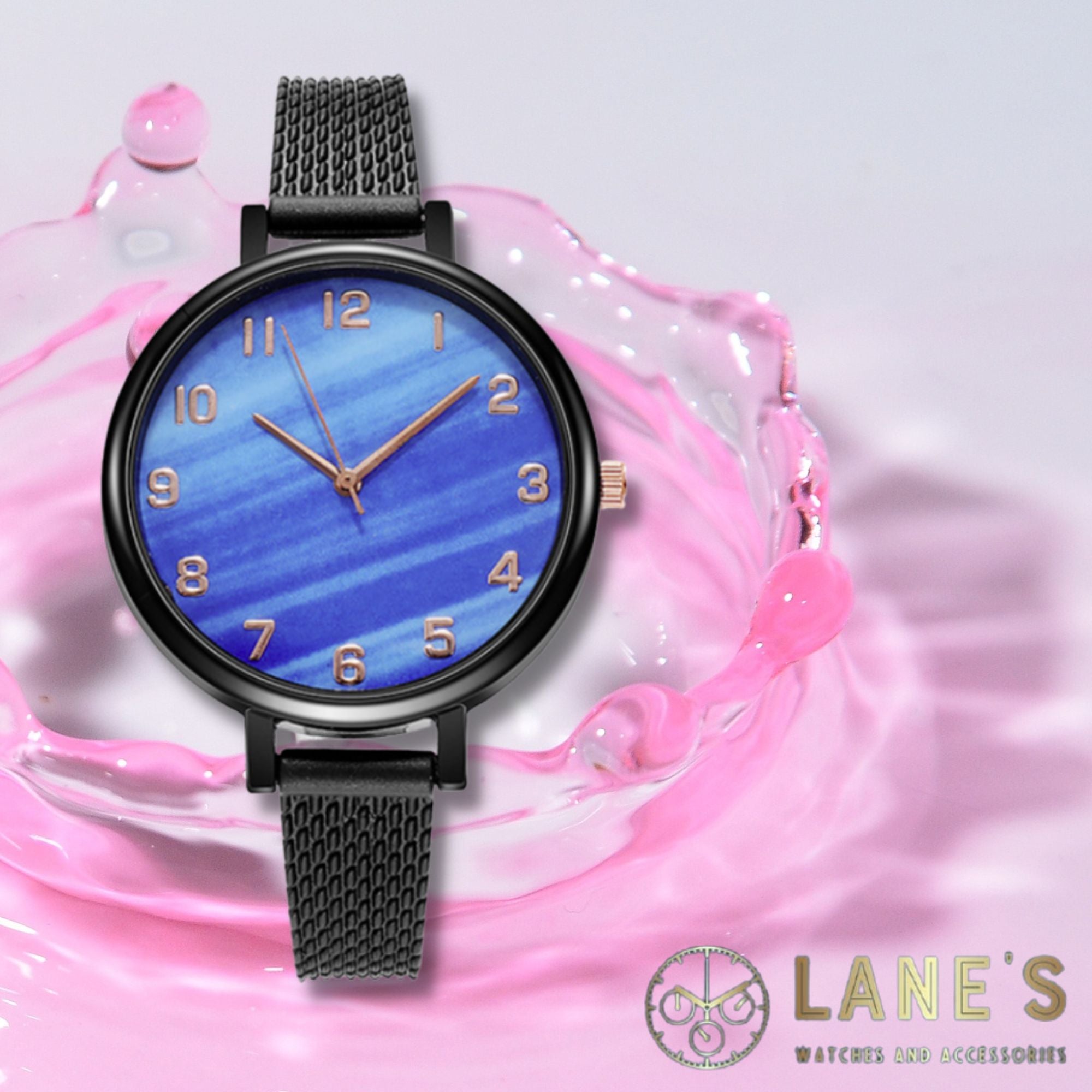 blue faced watch with gold numbers and a black trim with a black strap on a pink backgorund