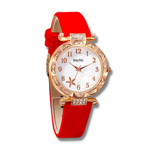 white faced watch with gold numbers and a gold trim with crystals and a red strap on a white background