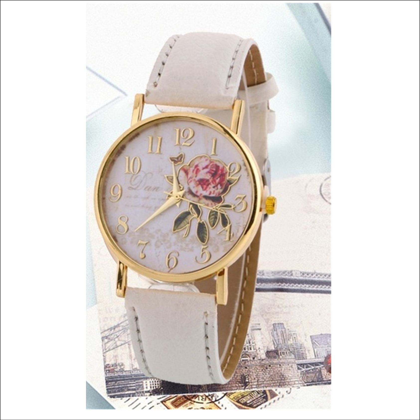 white faced watch with gold writing and a gold outlined rose with gold numbers on the dial with a gold trim and a creamy white strap