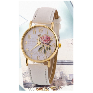 white faced watch with gold writing and a gold outlined rose with gold numbers on the dial with a gold trim and a creamy white strap