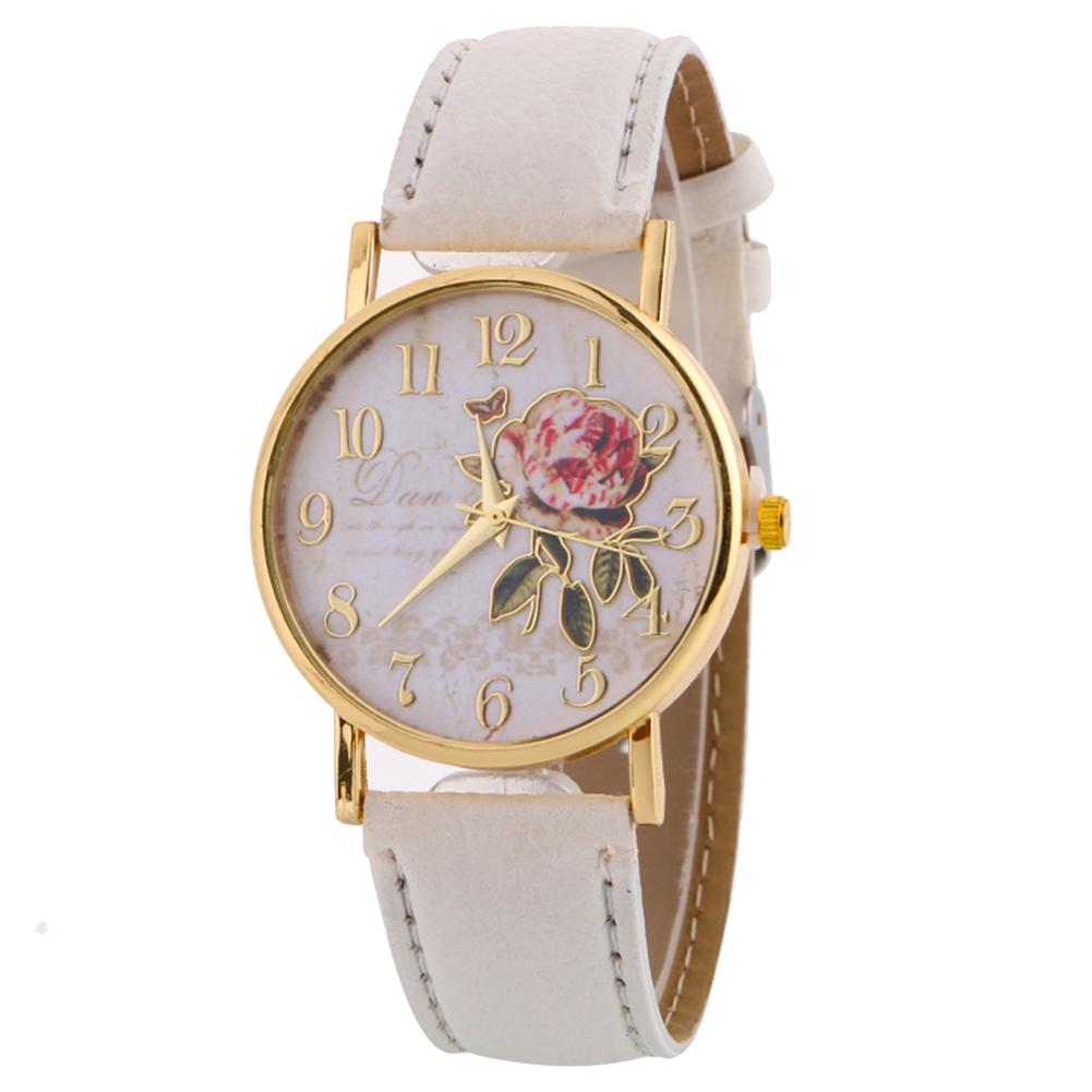 white faced watch with gold writing and a gold outlined rose with gold numbers on the dial with a gold trim and a creamy white strap on a white background