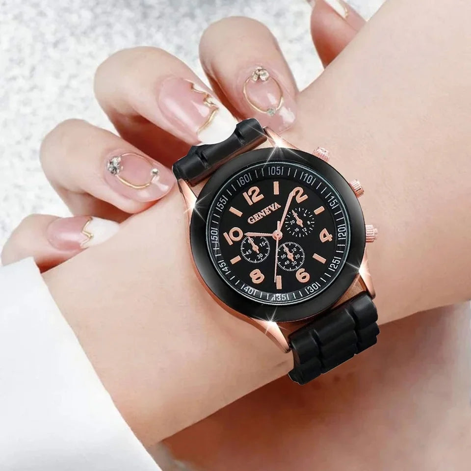 black faced watch with rose gold numbers counting up in twos with a black trim with rose gold edging with a rubbery black strap on a woman's wrist