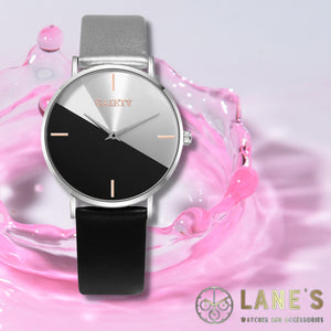 half black and half silver faced watch with 4 rose gold lines representing numbers with a silver trim and one black strap and one silver strap on a pink background